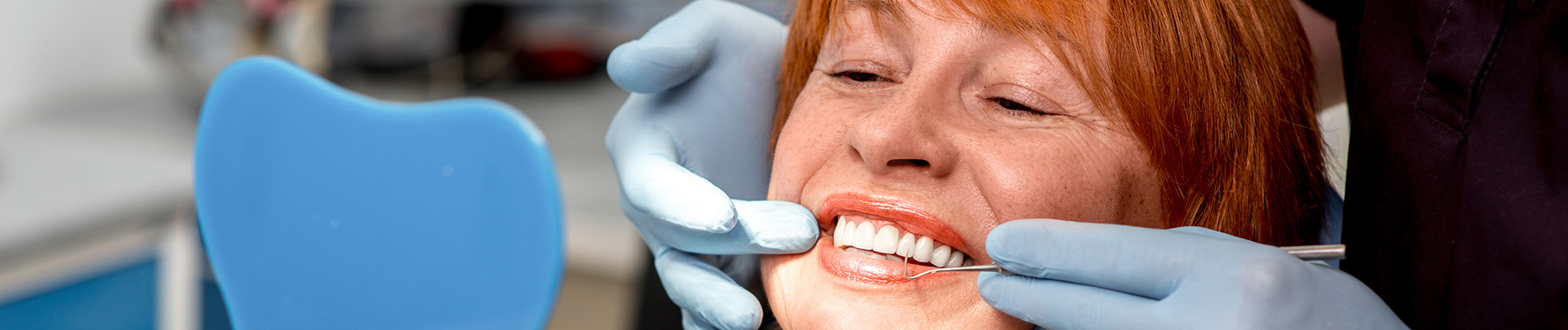 A well-lit reception area with a desk, computer monitor, and potted plant.